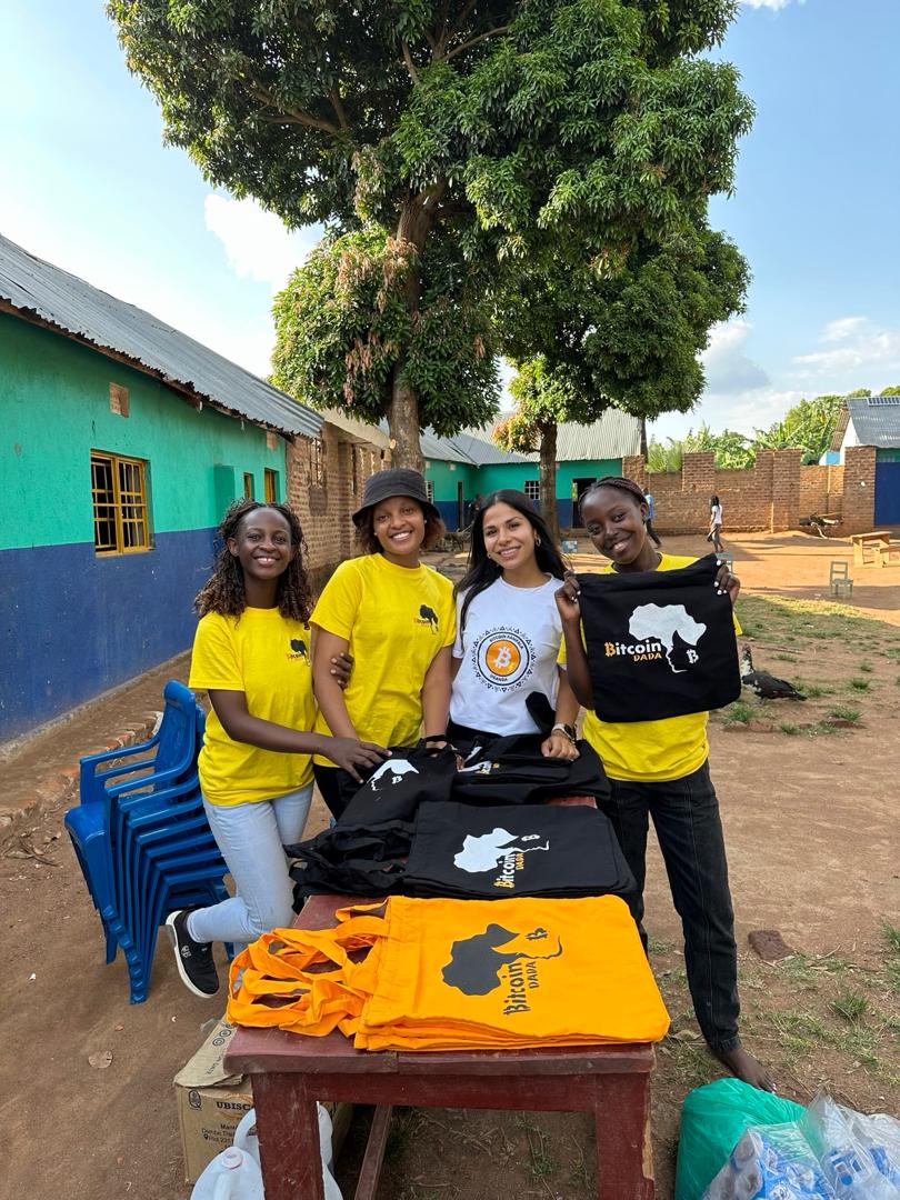 Anuja with three Bitcoin Dada members, holding tote bags printed with the Bitcoin Dada Africa logo